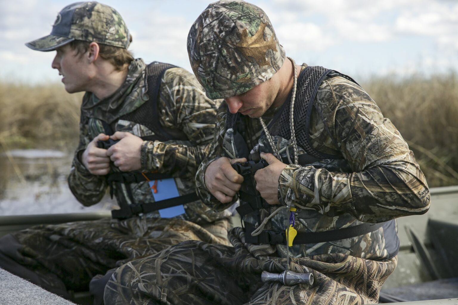 Hunters wearing camouflage hunting from a jon boat in the marsh along the St. Johns River near Christmas, Florida.