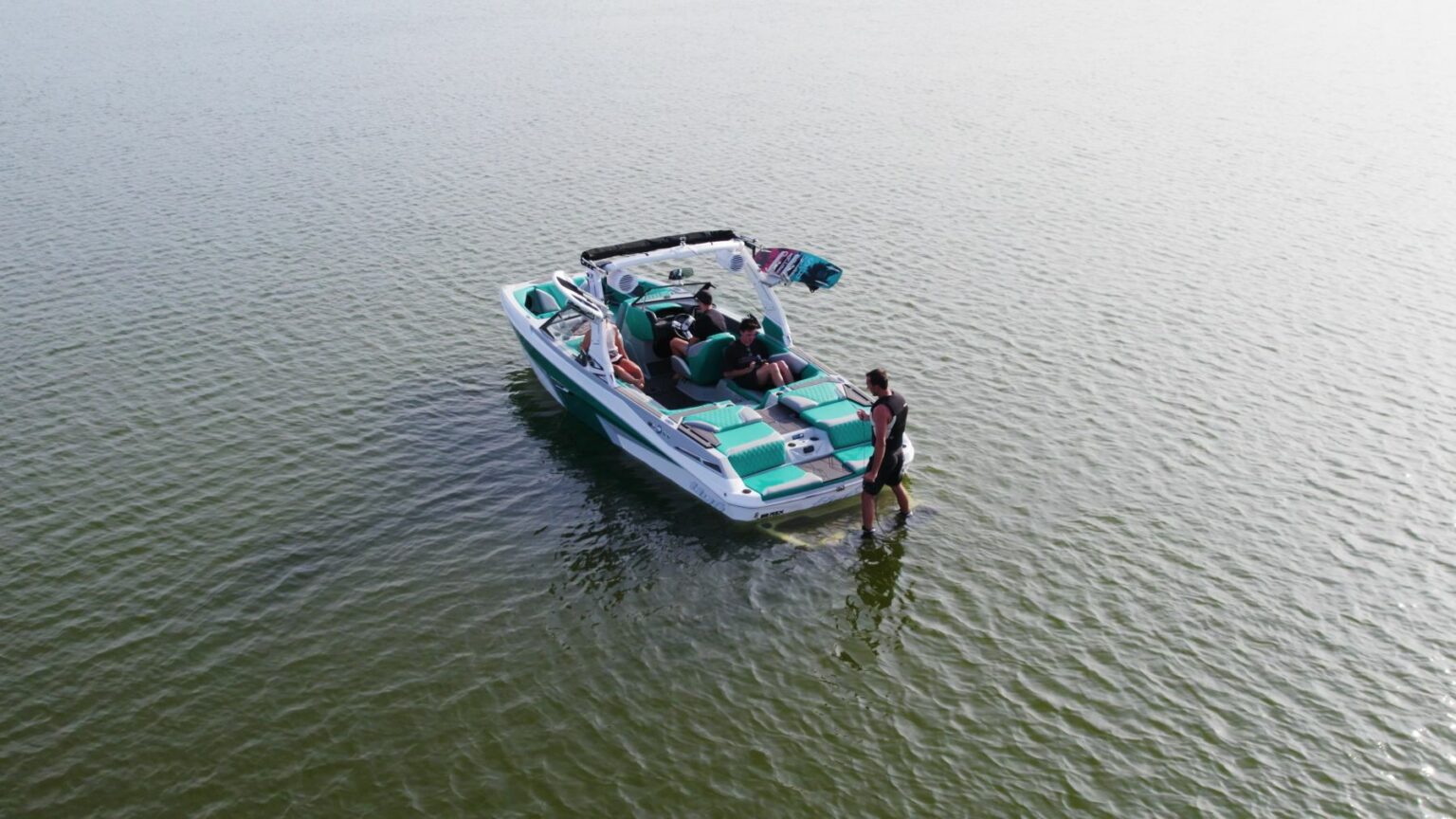 License-free image - Wakeboarder wearing a life vest is getting ready of the swim deck at the back of a ski boat on a lake. 