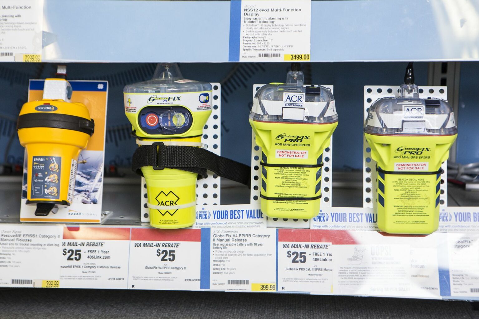 License-free image - Shelves in a store display various pieces of safety equipment, including polycarbonate EPIRBs (Emergency Position Indicating Radio Beacons) and other safety accessories with price tags and labels visible beneath them. The products are predominantly yellow and grey. EPIRB&#039;s (emergency position indicating radio beacon) on display at a retail outlet.