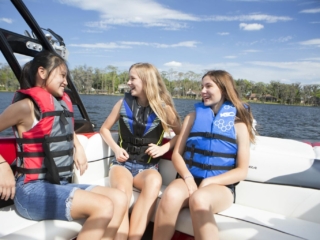 Kids having a fun afternoon on the water in properly fitting life jackets.