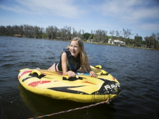 Kids having a fun afternoon on the water in properly fitting life jackets.