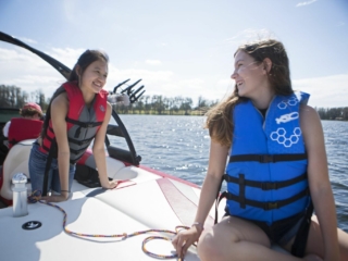 Kids having a fun afternoon on the water in properly fitting life jackets.