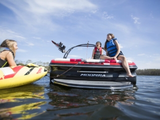 Kids having a fun afternoon on the water in properly fitting life jackets.