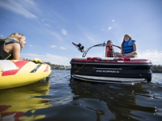 Kids having a fun afternoon on the water in properly fitting life jackets.