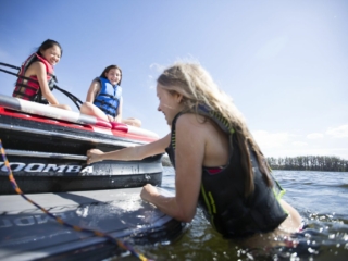 Kids having a fun afternoon on the water in properly fitting life jackets.