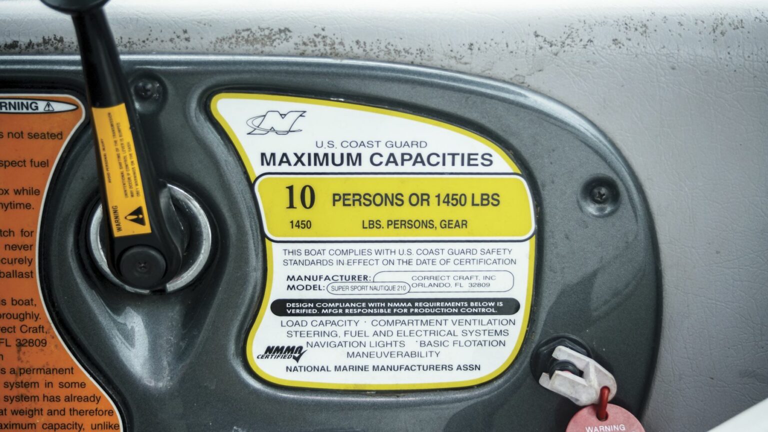 License-free image - A close-up image of a U.S. Coast Guard maximum capacities sign on a boat. The sign states a capacity of 10 persons or 1450 lbs, noting compliance with safety standards. It includes details on load capacity, manufacturer, model, and an NMMA certification. A capacity plate and certificate of compliance.